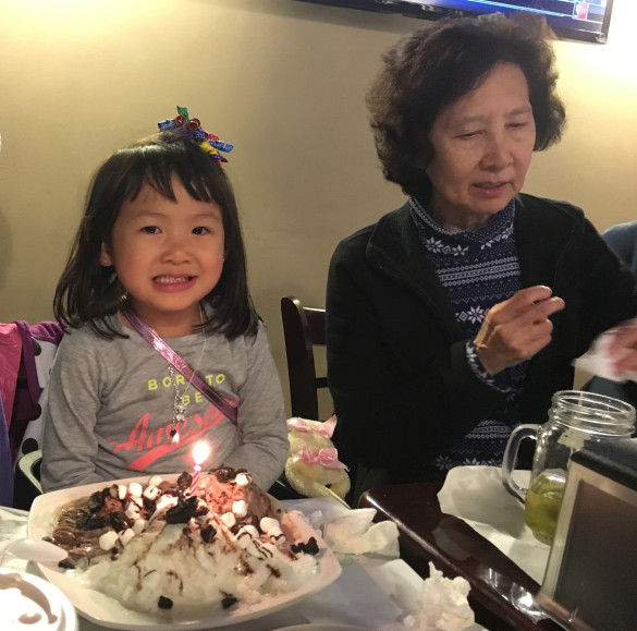 Roxy blowing out the candles on her shaved snow dessert at Crab City on her 4th birthday